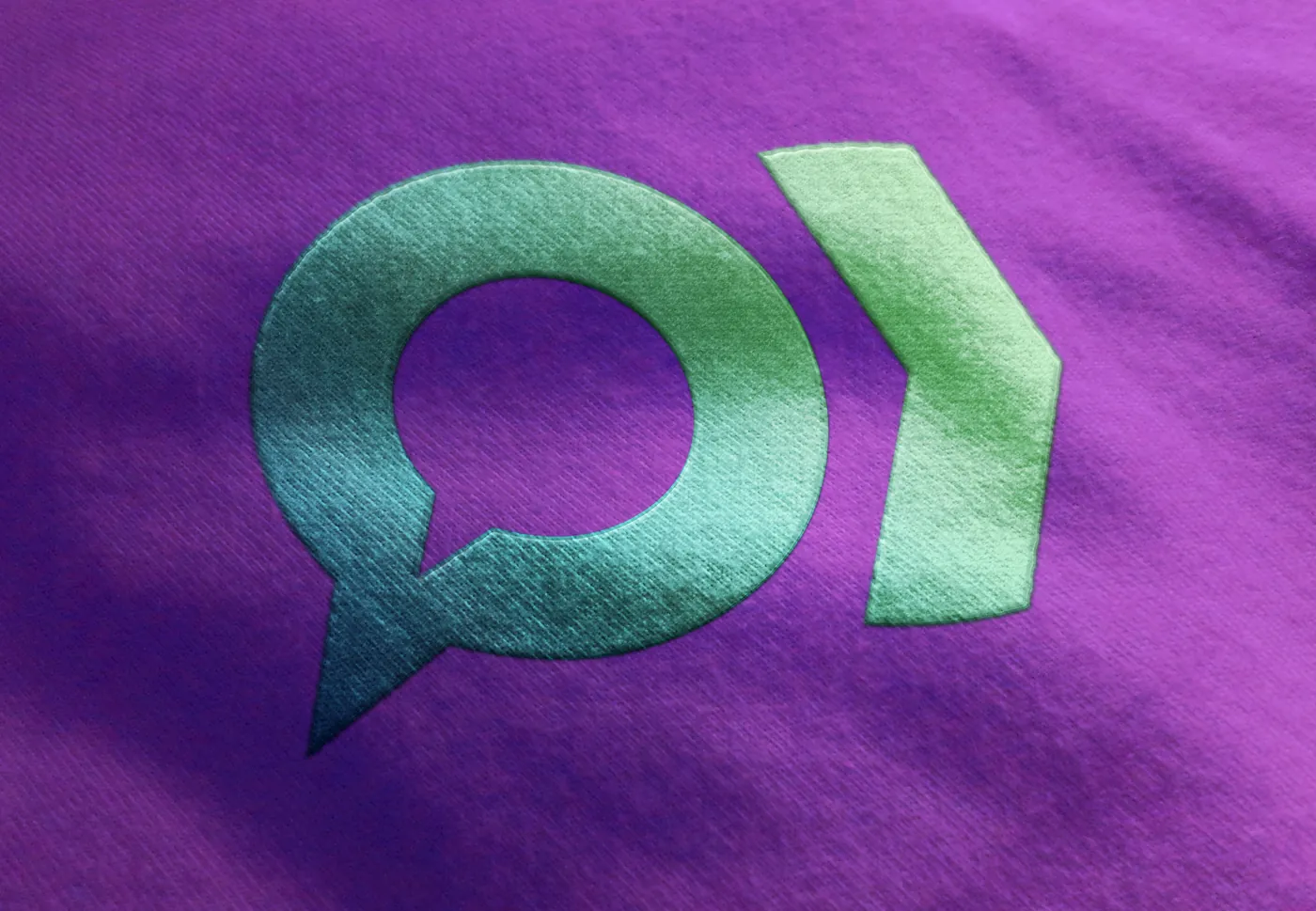 The 'OR' icon, speech bubble plus arrow, printed in teal-green on a purple shirt